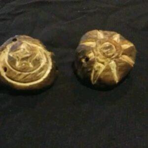 two knee caps hand carved with the sun and moon carved into the surface of the bones